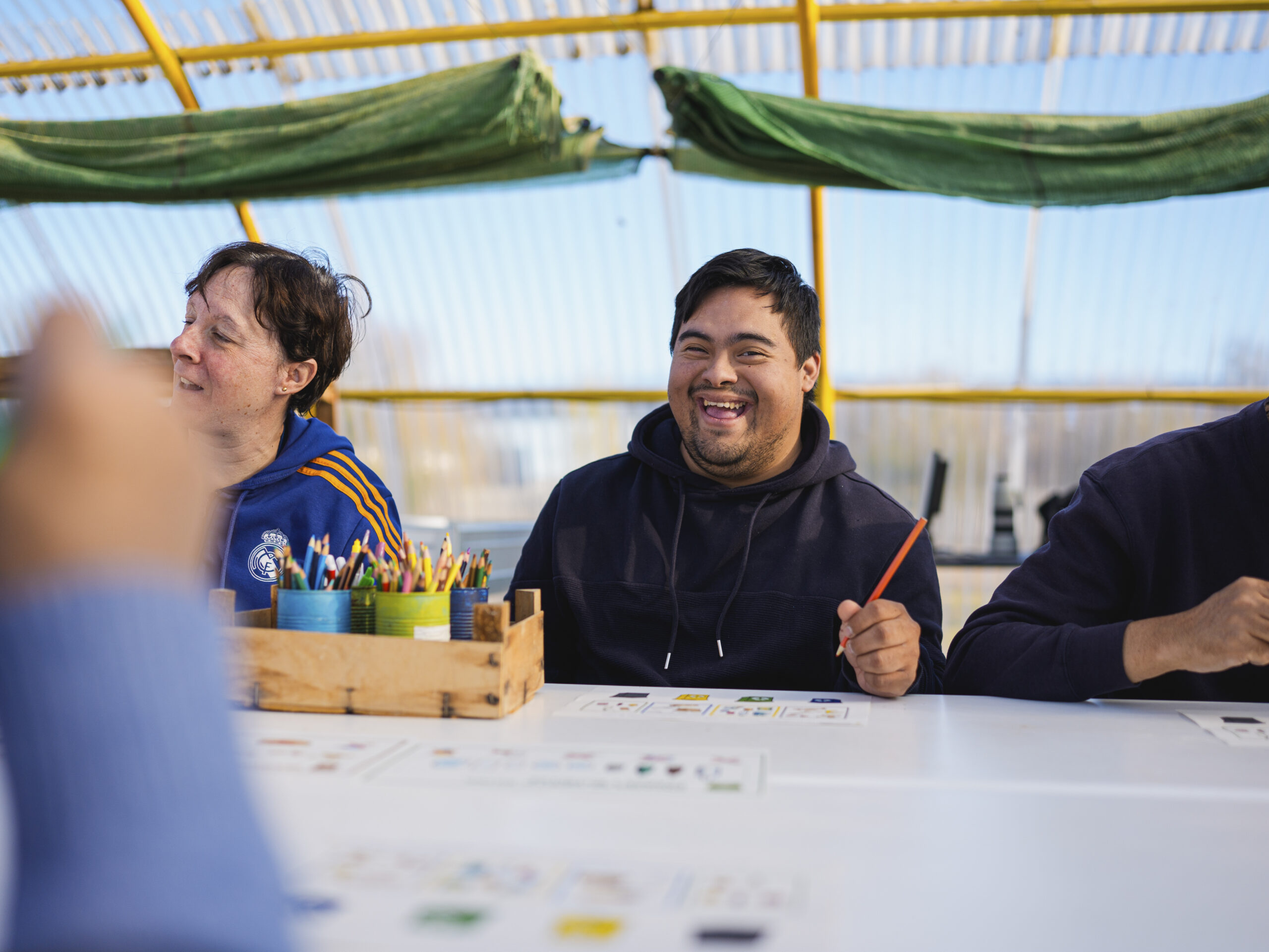 Joven con discapacidad disfrutando en un taller sobre reciclaje