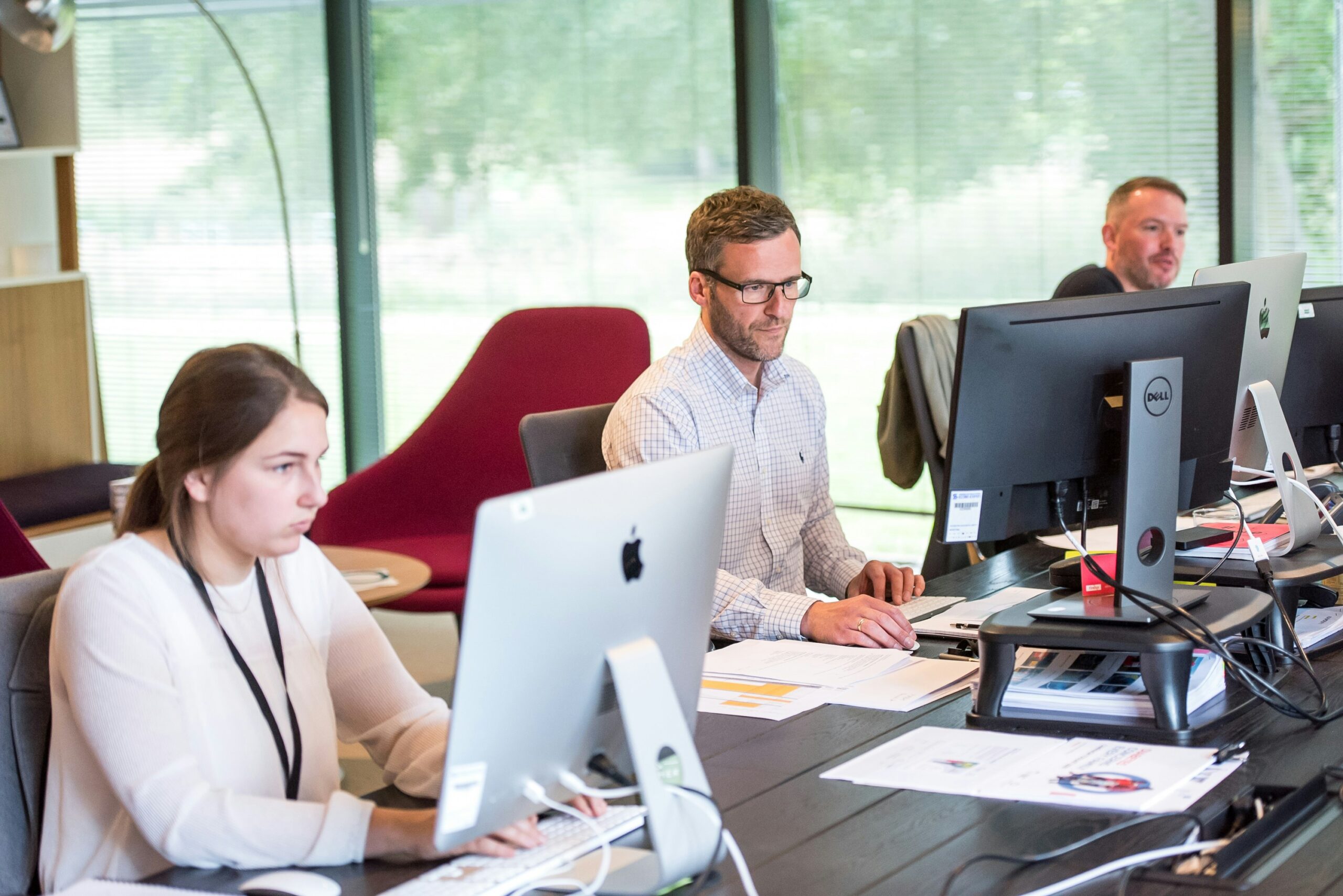 Personas trabajando en una oficina con sus ordenadores